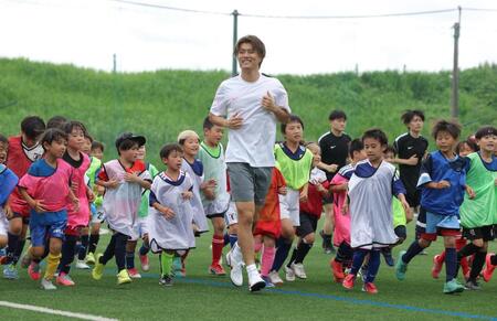 こどもたちとランニングする小川航基（中央）＝撮影・西岡正