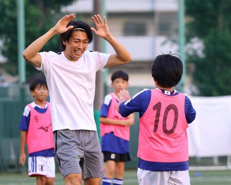 ミニゲームで得点を決めた子どもとタッチを交わす中村敬斗（撮影・石井剣太郎）