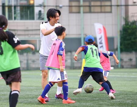 ミニゲームで得点を決めた子どもの頭をなでる中村敬斗（撮影・石井剣太郎）