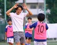 ミニゲームで得点を決めた子どもとタッチを交わす中村敬斗（撮影・石井剣太郎）