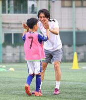 ミニゲームで得点を決めた子どもとタッチを交わす中村敬斗（撮影・石井剣太郎）