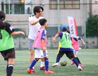 ミニゲームで得点を決めた子どもの頭をなでる中村敬斗（撮影・石井剣太郎）