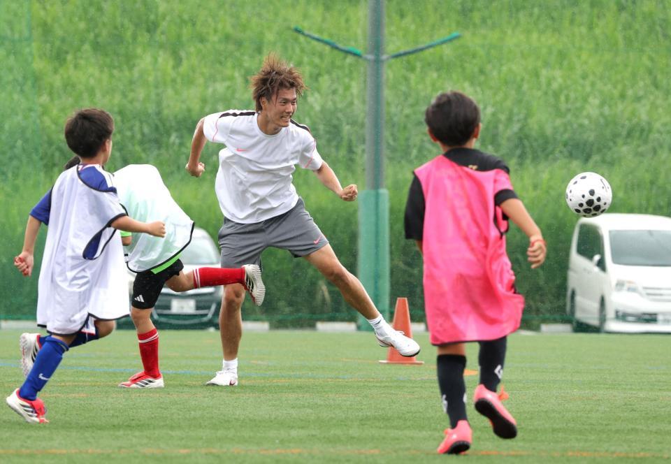 子どもたちとのゲームでヘディングシュートを決める小川航基（中央）＝撮影・西岡正