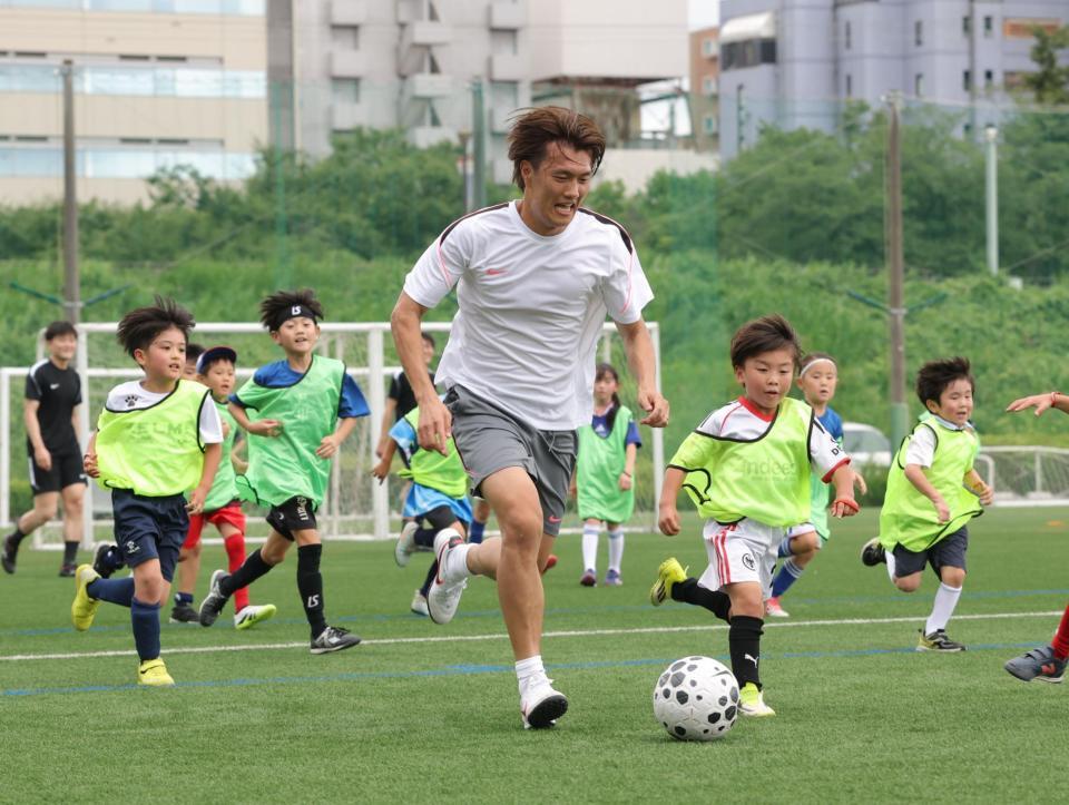 子どもたちとのゲームでボールを追う日小川航基（撮影・西岡正）
