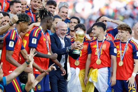 延長の末にアルゼンチンを破って優勝を果たし、トロフィーを手にするスペインのデラフエンテ監督（中央）＝ニューヨーク（共同）