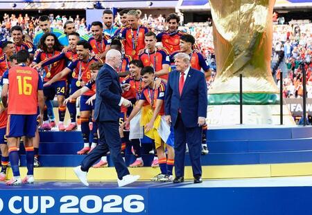 表彰式で立ち尽くすトランプ米大統領（右端）に駆け寄るＦＩＦＡのインファンティノ会長＝ニューヨーク（共同）