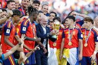 延長の末にアルゼンチンを破って優勝を果たし、トロフィーを手にするスペインのデラフエンテ監督（中央）＝ニューヨーク（共同）