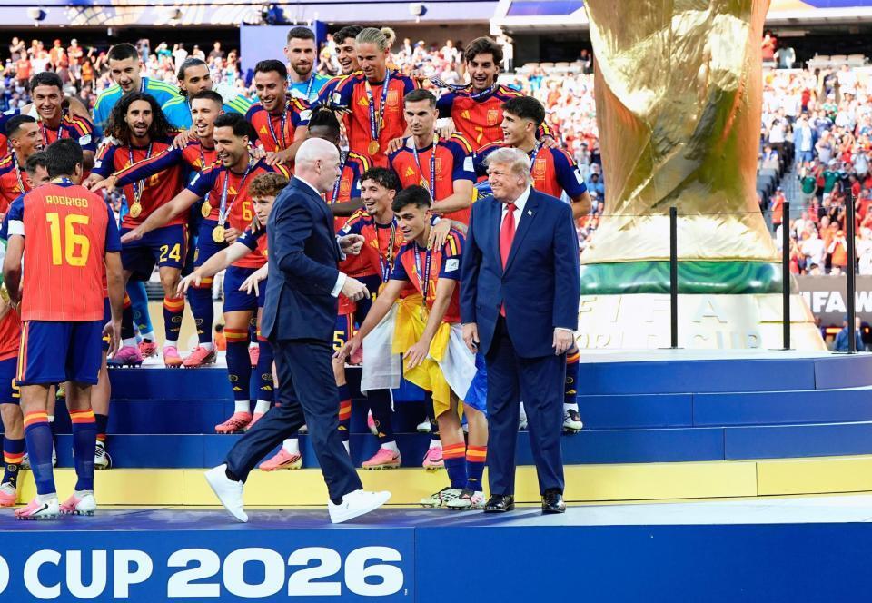 表彰式で立ち尽くすトランプ米大統領（右端）に駆け寄るＦＩＦＡのインファンティノ会長＝ニューヨーク（共同）