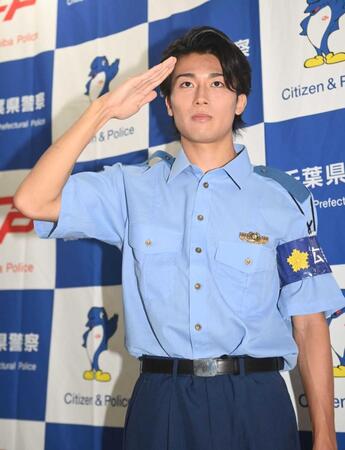 　千葉県警の少年犯罪実行者募集情報加担防止広報官の制服姿で敬礼するサッカー日本代表のＭＦ中村敬斗＝千葉・セブンパークアリオ柏屋外スマイルパーク（撮影・開出牧）