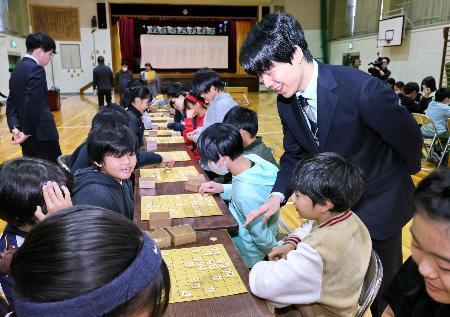 　愛知県瀬戸市の母校效範小で行われた授業にサプライズで登場し、６年生の対局を見守る将棋の藤井聡太七冠＝２１日午後（代表撮影）