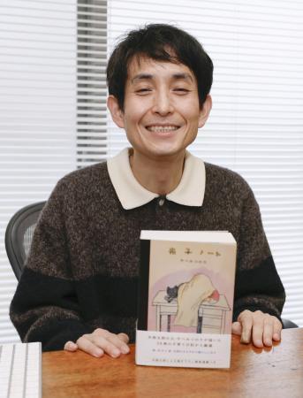 　出版した書籍と記念撮影する矢部太郎さん＝東京都内