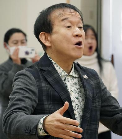 　「しあわせ運べるように」の合唱の指揮をする臼井真さん＝２０２４年１２月、神戸市北区