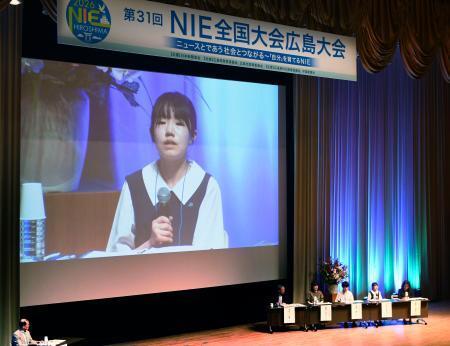 　スクリーンに映し出された、ＮＩＥ全国大会で発言する山田弥栄子さん＝３０日午後、広島市