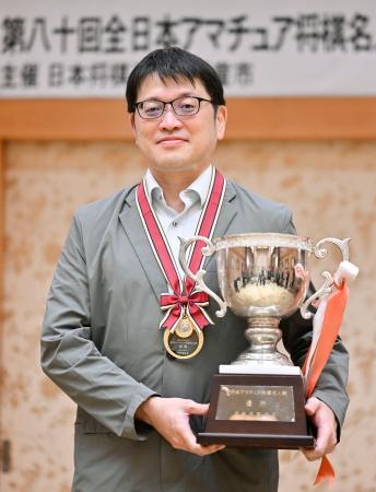 　第８０回全日本アマチュア将棋名人戦で優勝し、トロフィーを手にする天野啓吾さん＝１３日、山形県天童市