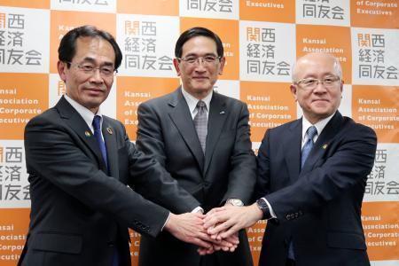 　関西経済同友会の次期代表幹事に決まり、写真に納まる長谷川一明氏。左は永井靖二代表幹事、右は三笠裕司氏＝２５日午後、大阪市北区