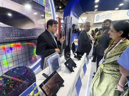 　半導体の国際展示会「セミコン・インディア」で、展示品の説明をする半導体関連企業の担当者（左）＝昨年９月、インド・ニューデリー