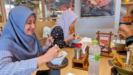 　インドネシア・ジャカルタに開店した「ラーメン・マニア」で、ハラル認証を取得したラーメンを食べるイスラム教徒の女性客ら（ＮＮＡ＝共同）