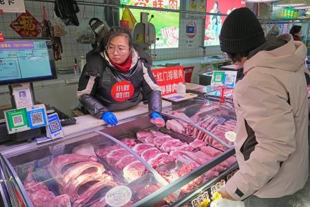 　北京市内の市場に並ぶ豚肉＝１月（共同）