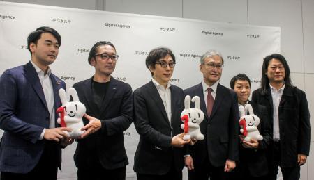 　デジタル在学証明の実証実験の報告会で、記念撮影する大学や企業の担当者ら＝１７日午後、東京都千代田区