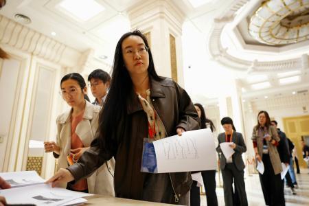 　中国国家統計局のＧＤＰ速報値に関する資料を受け取る報道関係者ら＝１６日、北京（共同）