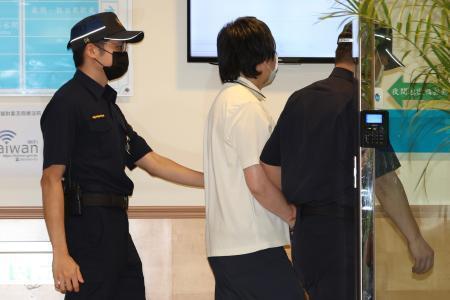 　判決公判に出廷するため裁判所に到着した陳力銘被告（中央）＝２７日、台湾・新北市（中央通信社＝共同）