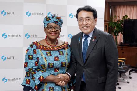 　会談前にＷＴＯのオコンジョイウェアラ事務局長（左）と握手する赤沢経産相＝１８日午後、経産省