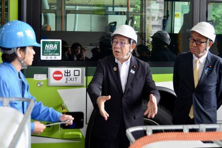 　バス会社の自動車整備場を視察する金子国交相（中央）＝１８日午前、東京都内