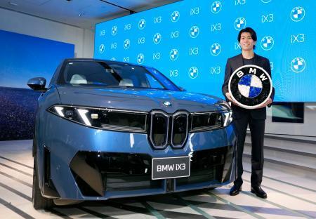 　ＢＭＷの新型ＥＶ「ＢＭＷ　ｉＸ３」と写真に納まるサッカー日本代表の中村敬斗選手＝２２日午後、東京都港区