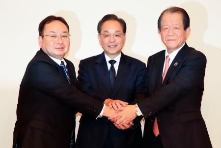 　記者会見を終え、ポーズをとるいよぎんＨＤの三好賢治社長（中央）ら＝２４日午後、松山市