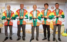 　台北市で開いた発表会で青森県産リンゴを手にアピールする、県りんご対策協議会の大場勉会長（中央）ら＝７日（共同）