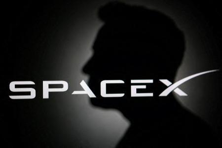 　イーロン・マスク氏のシルエットとスペースＸのロゴ＝６月１１日（ロイター＝共同）