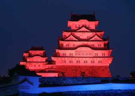 　万博開幕まで３００日となり、万博のイメージカラーの赤と青色にライトアップされた姫路城＝１７日夜、兵庫県姫路市