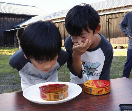 　シュールストレミングのにおいをかぐ兄弟＝１３日午後、三重県鳥羽市の海の博物館