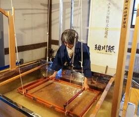 　紙すきを実演する細川紙の職人＝１日午後、京都市