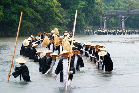 　伊勢神宮の式年遷宮に向けて行われた「御樋代木奉曳式」で、神木を綱で引く神宮司庁職員ら＝９日午後、三重県伊勢市の五十鈴川