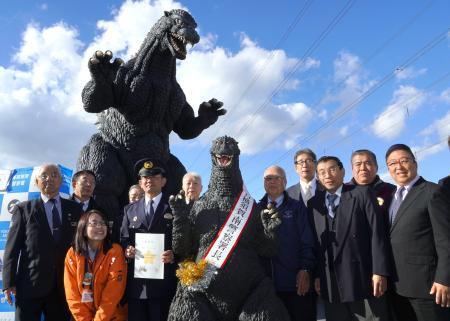 　神奈川県警横須賀南署の一日署長に委嘱された「ゴジラ」とイベント出席者ら＝１０日午後、神奈川県横須賀市