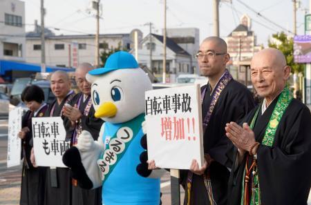 　自転車の青切符制度の周知や交通ルールの順守を呼びかける僧侶ら＝１３日午後、大阪市鶴見区