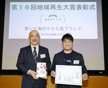 　「第１６回地域再生大賞　明日をともに創る～吹き始めた風」で大賞に選ばれた「東シナ海の小さな島ブランド」の山下賢太代表取締役（右）＝５日午後、東京の共同通信本社