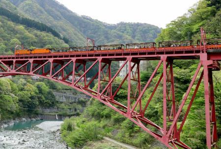 　運行を再開し、鉄橋を渡る黒部峡谷鉄道のトロッコ電車＝２０日午前、富山県黒部市
