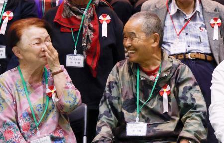 　大分県立学びケ丘中の入学式を終え、他の新入生らと談笑する尾畠春夫さん（右）＝２１日午後、大分市