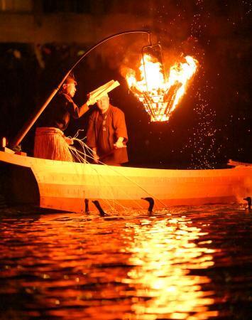　「長良川鵜飼」が開幕し、かがり火の下でウを操る鵜匠＝１１日夜、岐阜市
