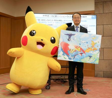 　石川県庁を訪れたポケモンのキャラクター「ピカチュウ」と写真に納まる山野之義知事＝１４日午後