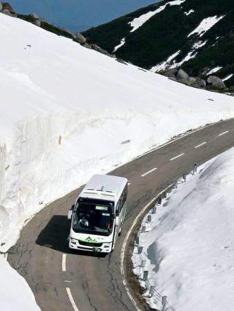 　冬季閉鎖期間が終わり開通した「乗鞍スカイライン」を走るバス＝１５日午前、岐阜県高山市