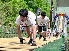 　スキージャンプ台を駆け上がる人たち＝１６日午前、札幌市の大倉山ジャンプ競技場