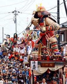 　北陸三大祭りの一つとして知られる「三国祭」で、源義経（手前）などの巨大な武者人形を載せて町中を巡行する山車＝２０日午後、福井県坂井市