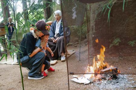 　松江市東出雲町の黄泉比良坂で行われた、故人への手紙を奉納し火にくべる「たき上げ」＝２１日午前