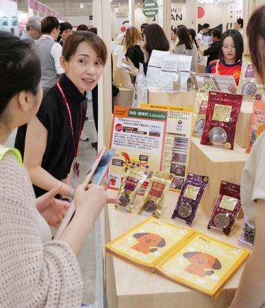 　「台北ペットショー」で自社製品を紹介するオリエント商会の田畑千子専務（左から２人目）＝３日、台北市（共同）