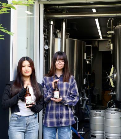 　クラフトビール「酔（よ）いちご」の開発に取り組む大学生。奥は醸造用のタンク＝６月、水戸市