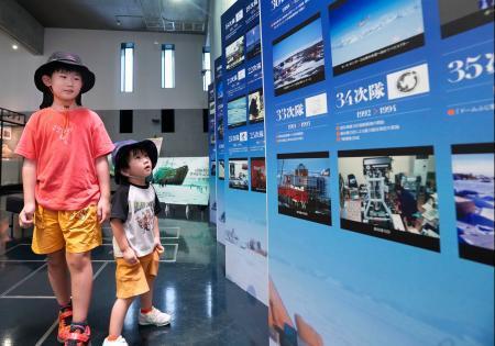 　南極観測の歴史を振り返る記念写真展を楽しむ男の子＝６日、東京都立川市