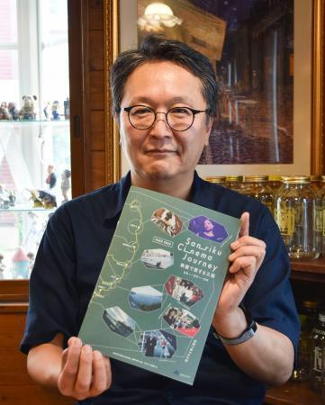 　ガイドブック「Ｓａｎｒｉｋｕ　Ｃｉｎｅｍａ　Ｊｏｕｒｎｅｙ」を手にする有坂民夫さん＝６月、盛岡市